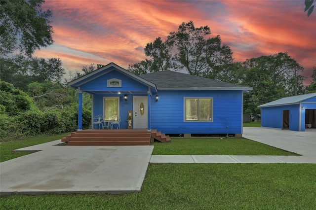 view of front of home with a lawn, an outbuilding, and covered porch