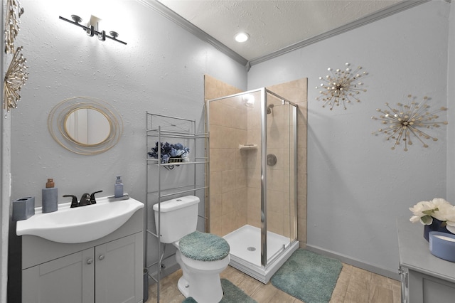 bathroom with a textured ceiling, an enclosed shower, vanity, toilet, and ornamental molding