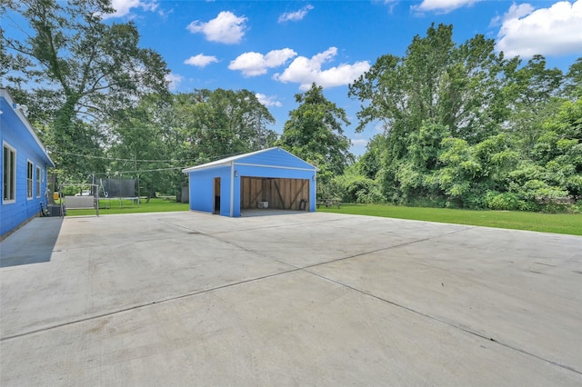 garage featuring a trampoline and a lawn