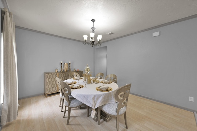 dining space featuring a notable chandelier, crown molding, and light hardwood / wood-style floors