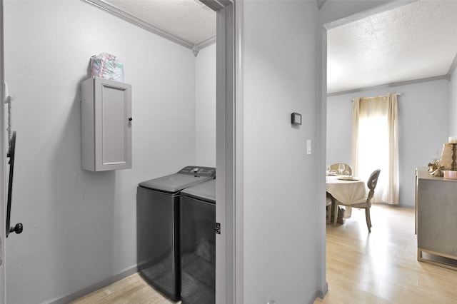 laundry room with a textured ceiling, ornamental molding, and independent washer and dryer