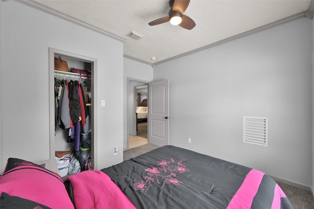 bedroom featuring ceiling fan, a closet, crown molding, and carpet floors