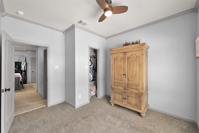 carpeted bedroom featuring ceiling fan, a closet, and crown molding