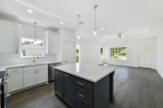 kitchen with sink, white cabinetry, stainless steel appliances, a center island, and decorative backsplash