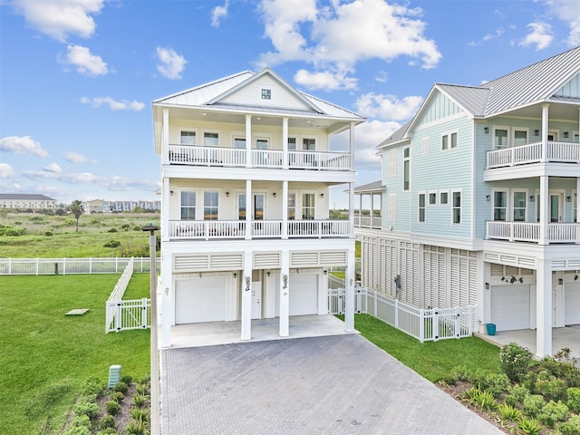 beach home with a garage, a balcony, and a front lawn