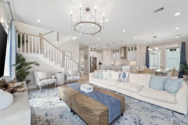 living room featuring hardwood / wood-style flooring, crown molding, and an inviting chandelier