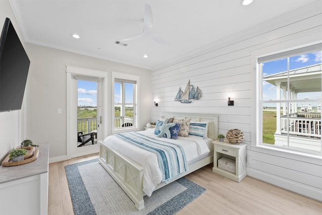 bedroom with access to outside, ceiling fan, wooden walls, and light wood-type flooring