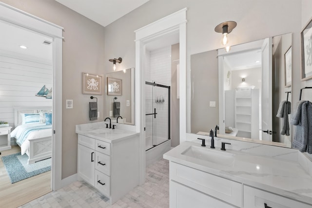 bathroom with a shower with door, vanity, hardwood / wood-style floors, and ornamental molding