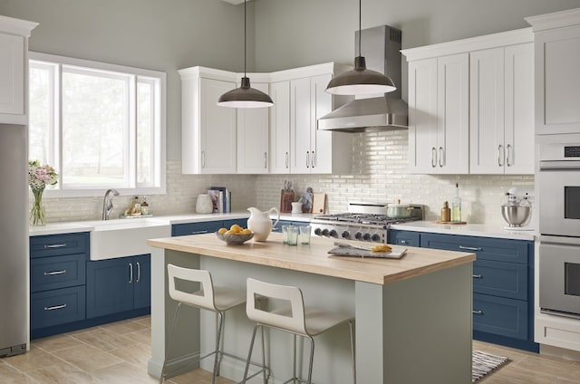 kitchen featuring blue cabinetry, backsplash, and white cabinetry