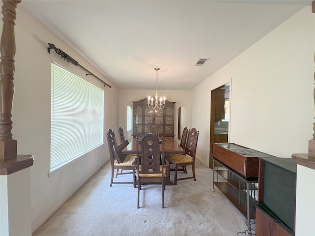 dining room with carpet and an inviting chandelier