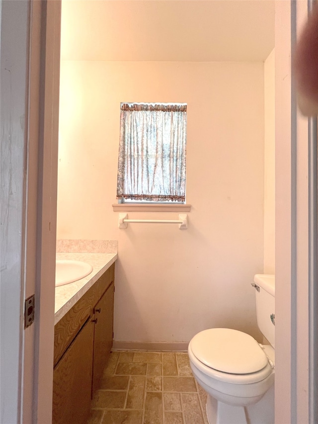 bathroom featuring tile floors, vanity, and toilet