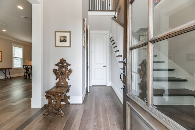 entryway featuring wood-type flooring and ornamental molding