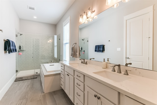 bathroom with tile floors, double sink, plus walk in shower, and vanity with extensive cabinet space