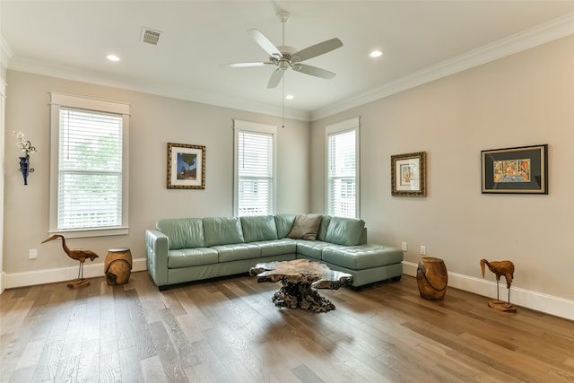 living room with a healthy amount of sunlight, hardwood / wood-style floors, ornamental molding, and ceiling fan