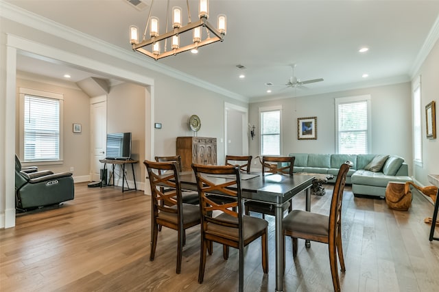 dining space featuring ornamental molding, ceiling fan with notable chandelier, and light hardwood / wood-style flooring