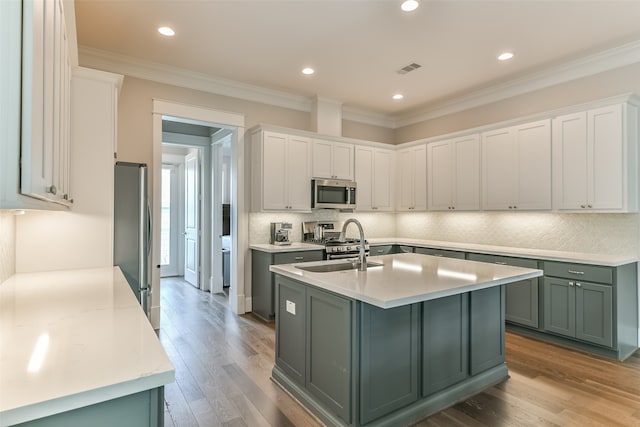 kitchen featuring green cabinetry, white cabinets, hardwood / wood-style flooring, and appliances with stainless steel finishes