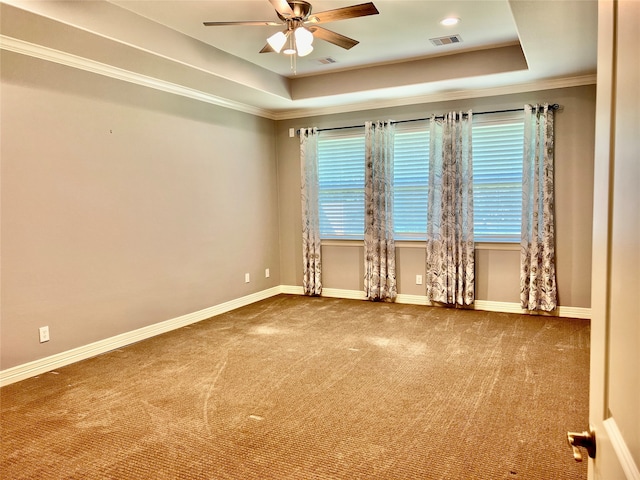 carpeted spare room featuring ceiling fan, a raised ceiling, and crown molding