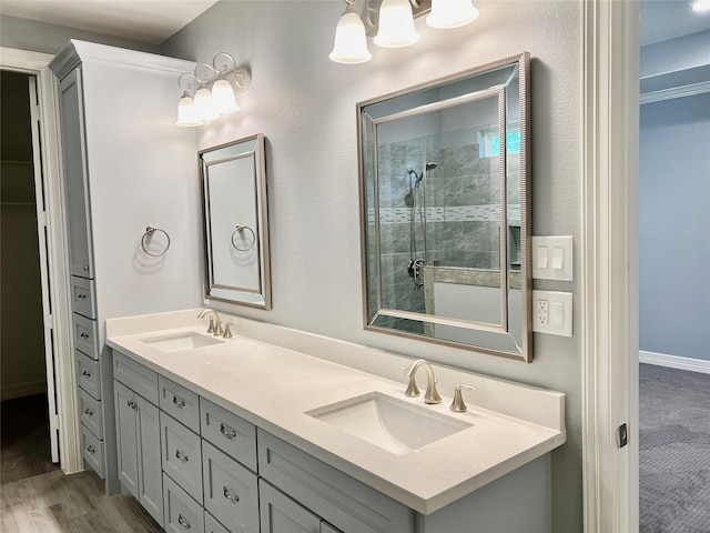 bathroom with hardwood / wood-style floors, a shower with door, and vanity