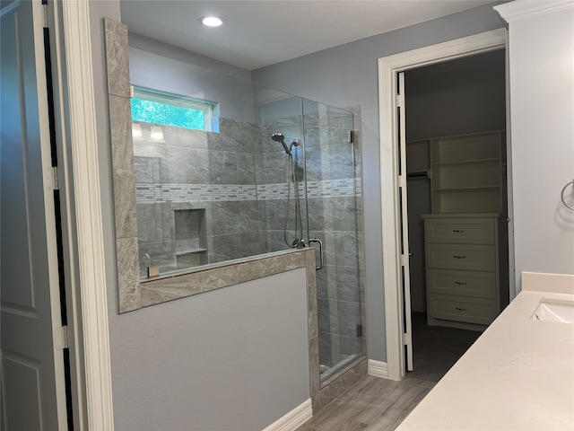 bathroom featuring a shower with door, wood-type flooring, and vanity