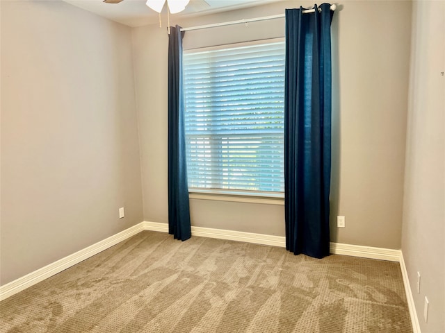 carpeted spare room featuring ceiling fan