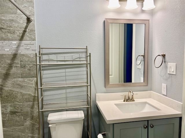 bathroom with radiator heating unit, vanity, tiled shower, and toilet