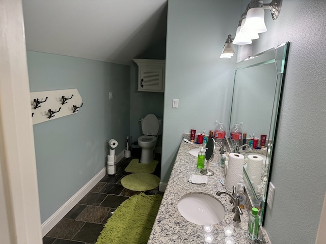 bathroom with tile floors, toilet, and dual bowl vanity