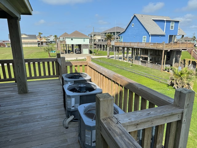 wooden deck featuring a lawn and central AC unit