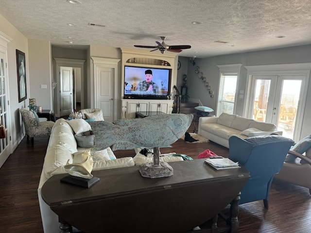 living room with french doors, dark wood-type flooring, ceiling fan, and a textured ceiling