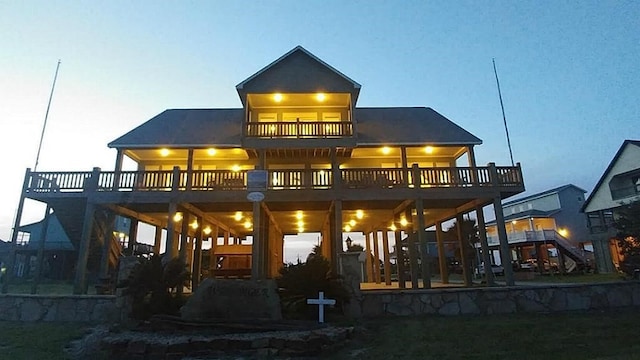 back house at dusk with a patio area and a balcony