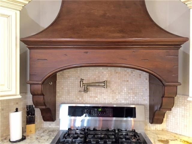 room details with light stone countertops, backsplash, and range