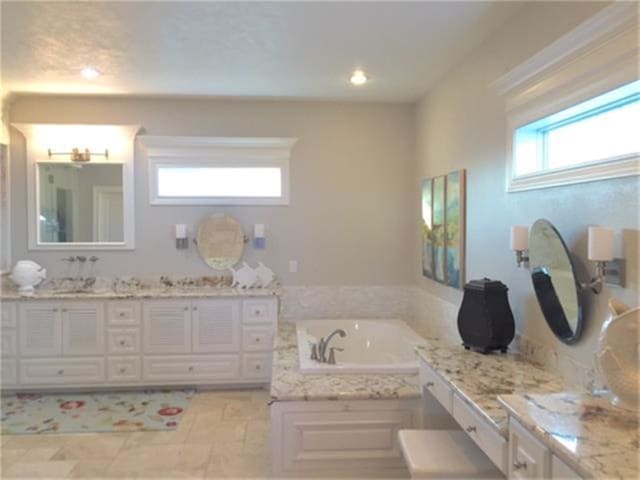 bathroom featuring a tub, tile flooring, and vanity