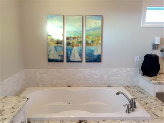 bathroom featuring vanity and a tub