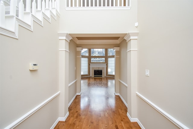 hallway featuring crown molding, a towering ceiling, and hardwood / wood-style floors