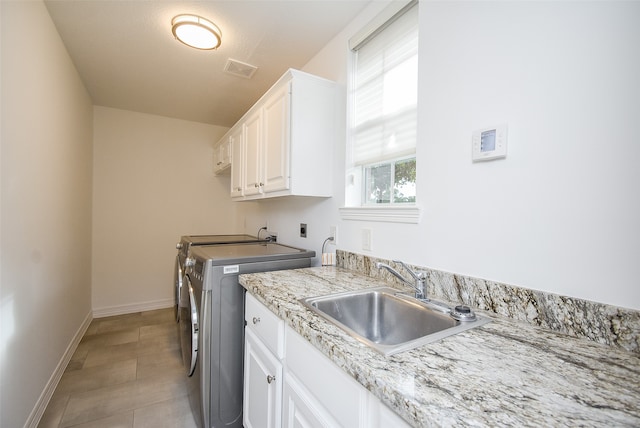 washroom with light tile patterned floors, cabinets, sink, and independent washer and dryer