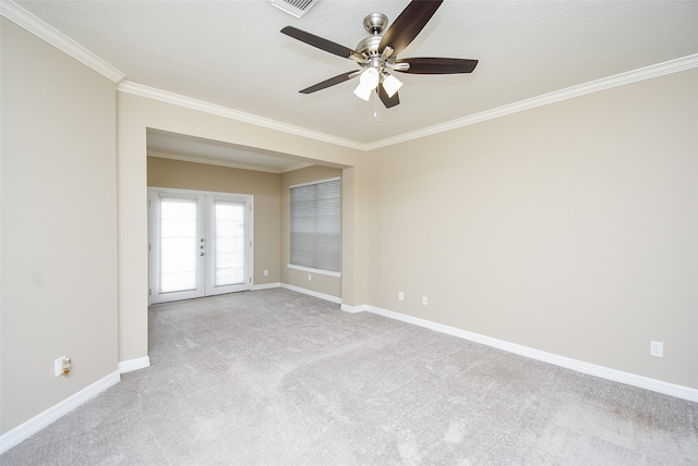 spare room featuring a textured ceiling, crown molding, ceiling fan, french doors, and light colored carpet