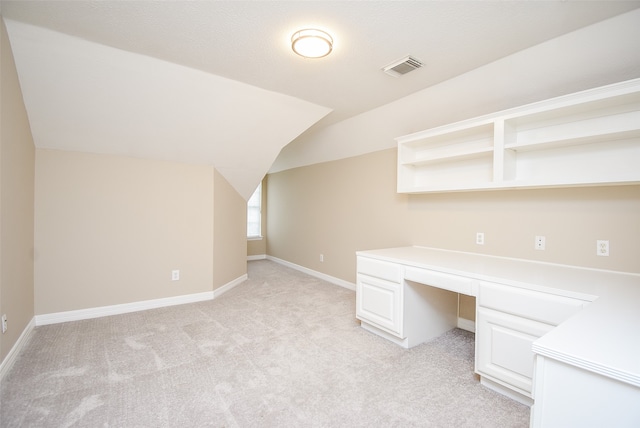 unfurnished office featuring light colored carpet and lofted ceiling