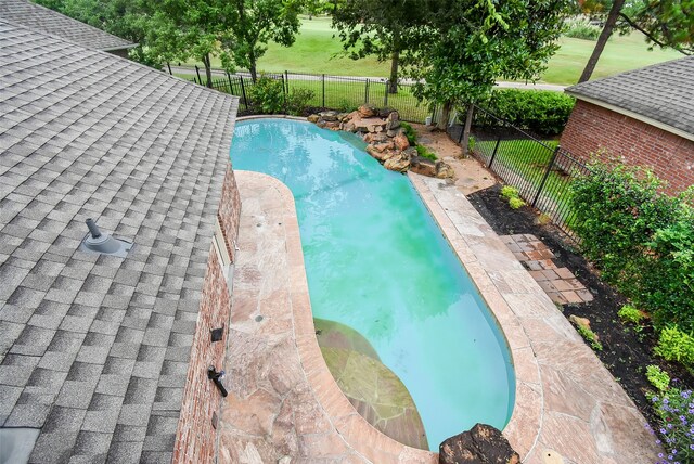 view of swimming pool with a yard