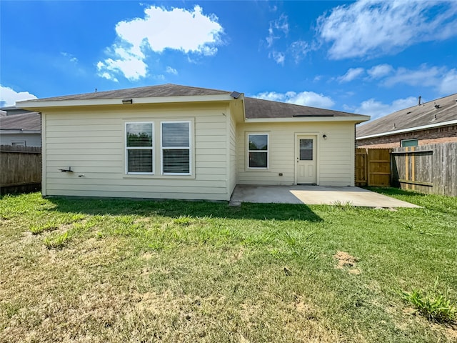 rear view of property featuring a patio area and a yard