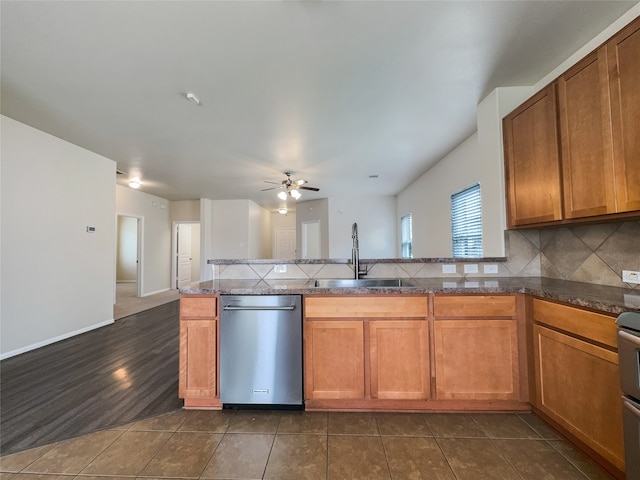 kitchen with ceiling fan, stainless steel dishwasher, backsplash, sink, and dark tile floors