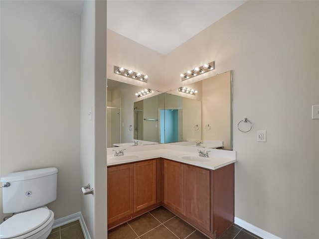 bathroom featuring tile flooring, vanity with extensive cabinet space, double sink, and toilet