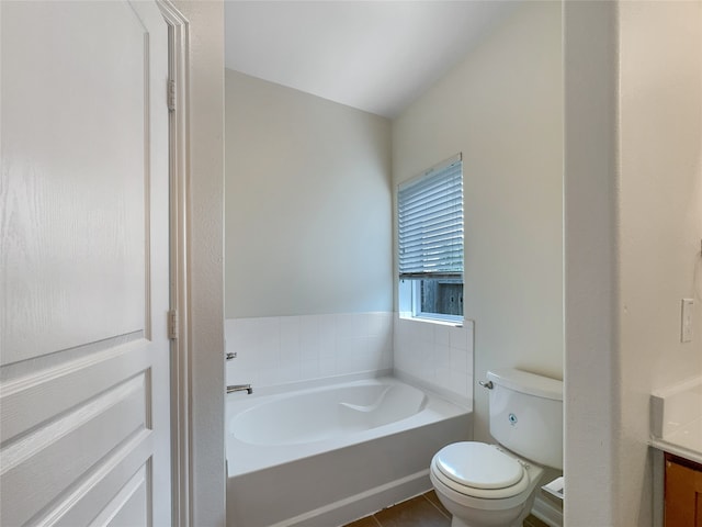 bathroom featuring tile floors, a bathing tub, toilet, and vanity