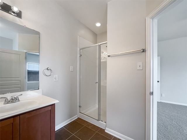 bathroom with tile floors, a shower with door, and vanity