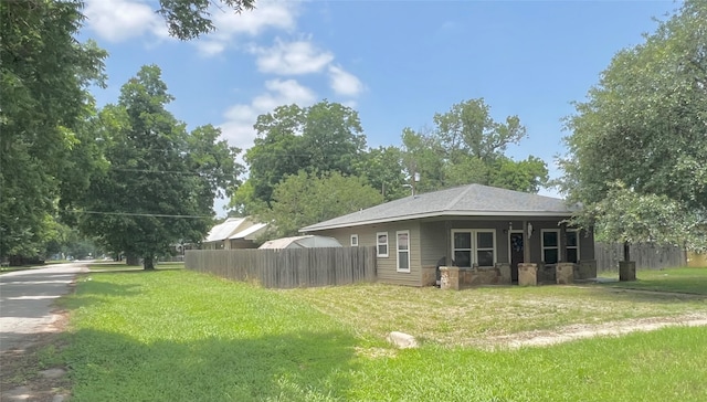 view of home's exterior with a lawn and fence