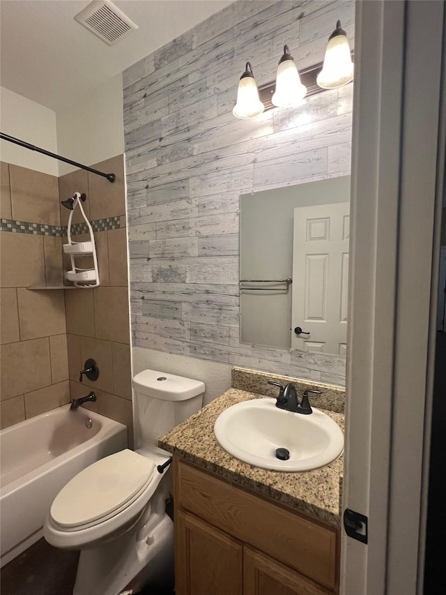 bathroom featuring vanity, toilet, visible vents, and shower / bath combination