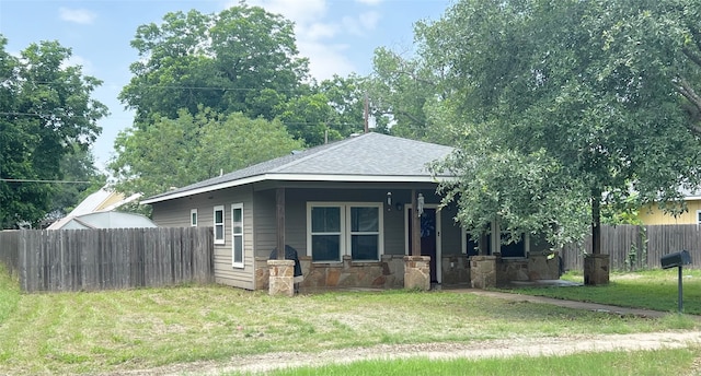 bungalow-style house featuring a front yard, a porch, fence, and a shingled roof