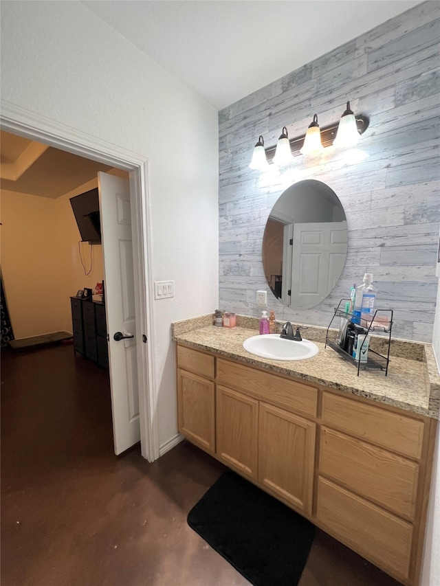 bathroom featuring concrete flooring, vanity, and wood walls