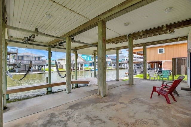 view of terrace with a water view and a dock