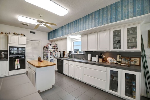 kitchen with dark tile floors, ceiling fan, black appliances, white cabinets, and sink