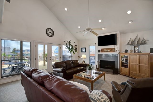 living room featuring high vaulted ceiling, french doors, ceiling fan, and light colored carpet