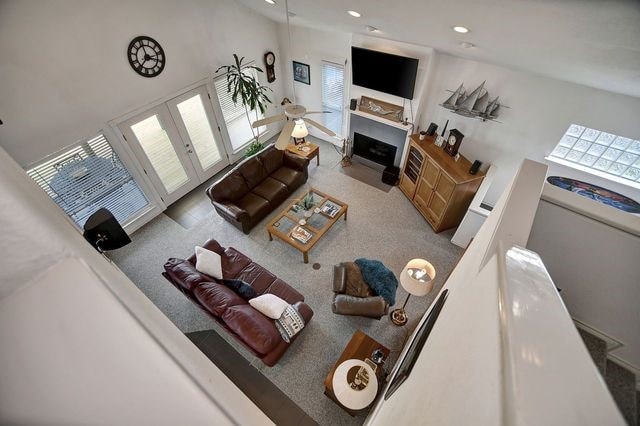 living room with carpet, a towering ceiling, and french doors